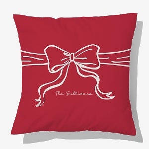 A green personalized pillow with a bow and the names, Emma & Jacob, written on it