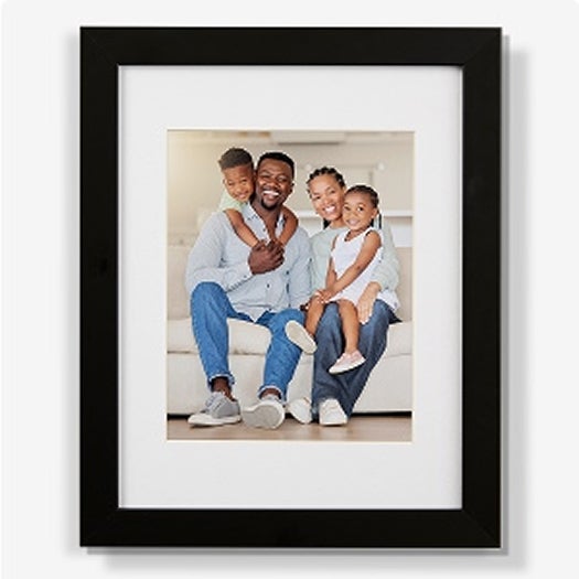 A photo frame with a photo of a family smiling on it