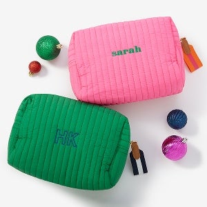 A pink makeup bag with the name Sarah on it and a green bag with the initials HK