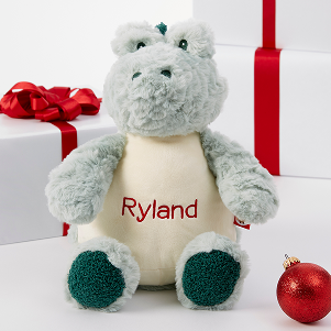 A green crocodile stuffed animal with the name Ryland written on it
